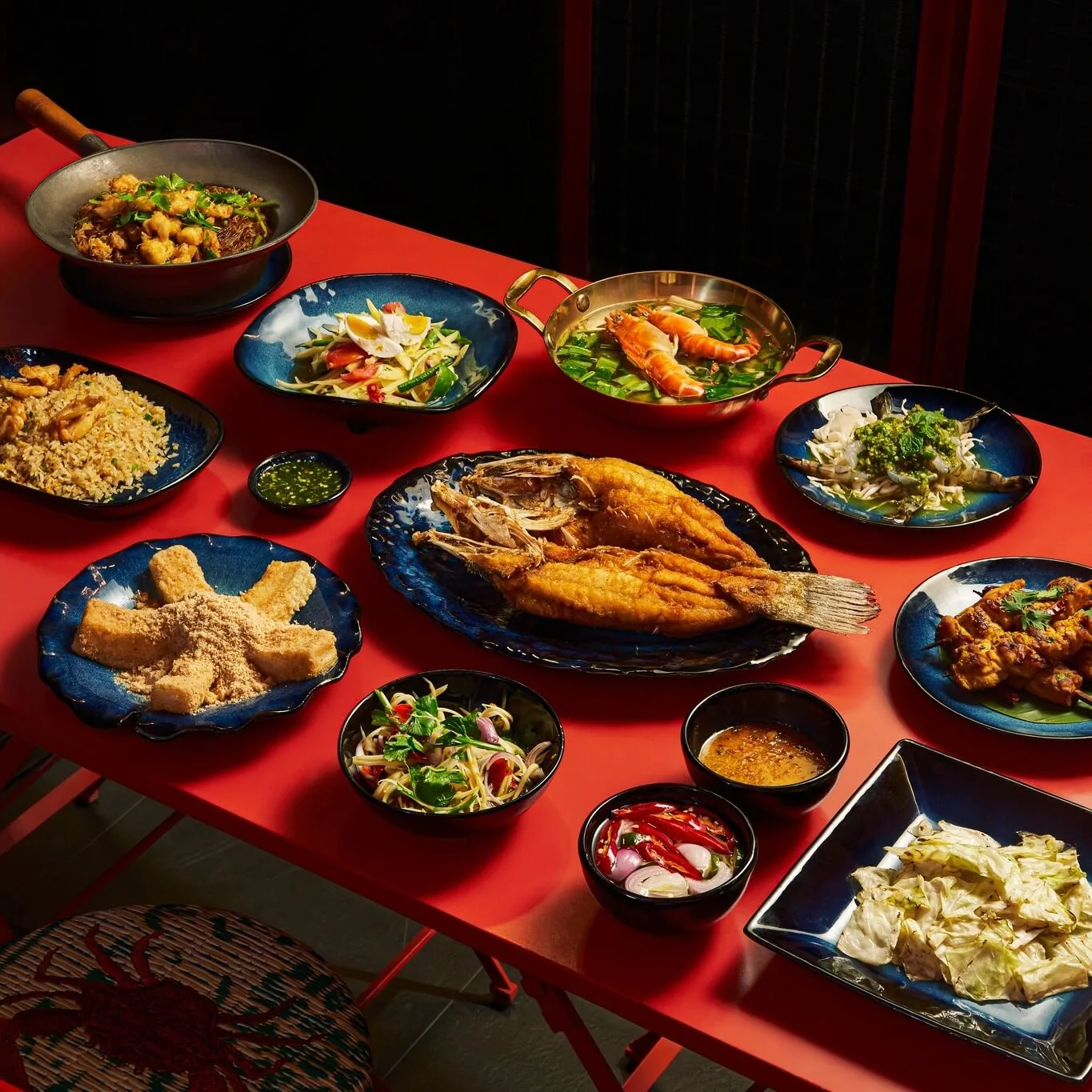 Sumptuous Thai seafood banquet showcasing giant river prawn Tom Yum Goong and crispy fried sea bass