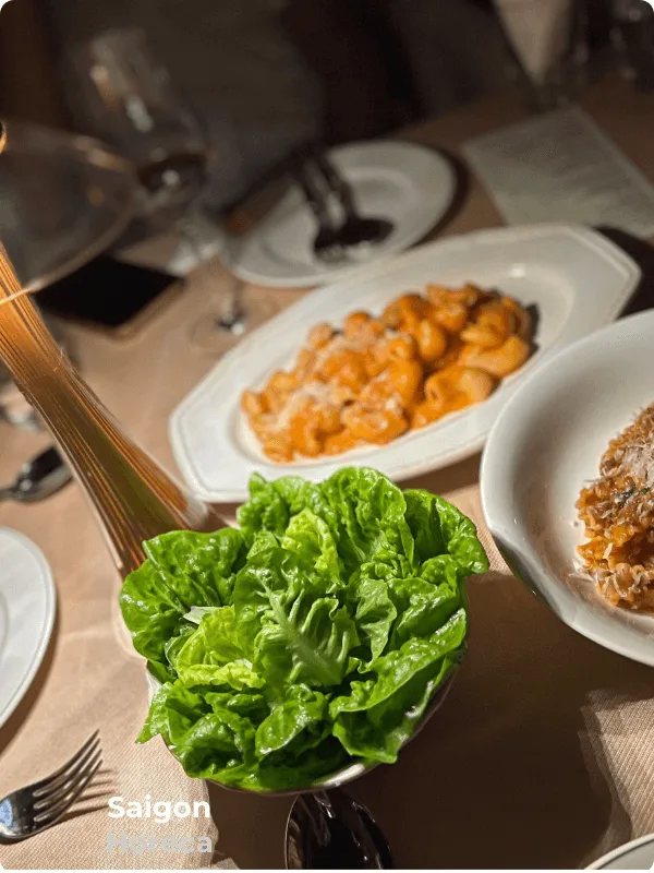 Fresh garden salad alongside tomato cream pasta at Bambino