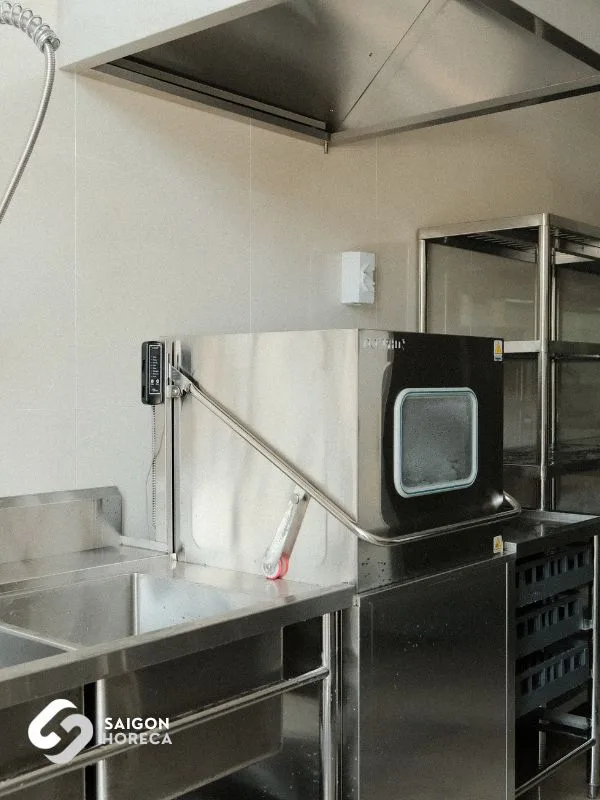 Commercial stainless steel dishwasher positioned beside soaking sinks and tray drying racks at the Sheh Fung kitchen