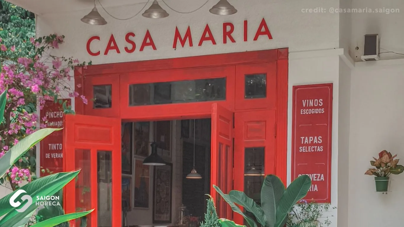 Signature red doorway facade and store signage at Casa Maria