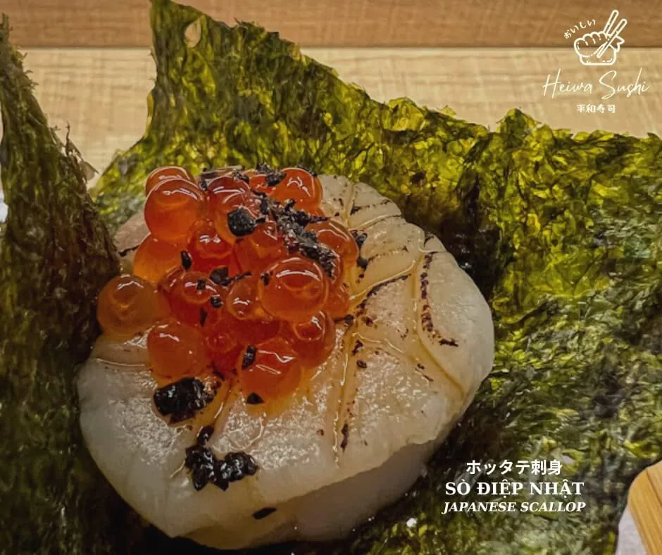 Flame-seared Japanese scallop topped with glistening salmon roe on crisp nori seaweed at Heiwa Sushi - Saigon Horeca