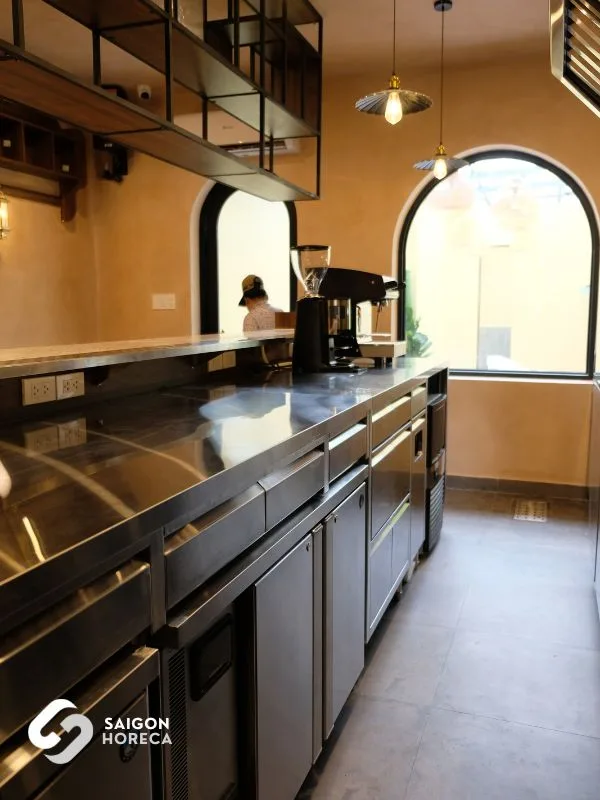 Seamless stainless steel counter run integrating espresso machine and undercounter refrigeration—optimizing barista ergonomics within tight spatial limits
