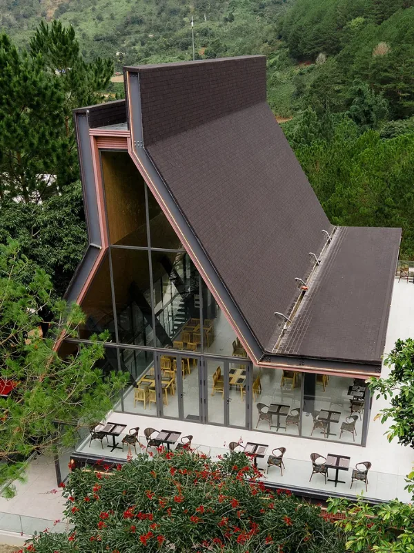 Pitched-roof vernacular architectural dining pavilion nestled among towering pine trees