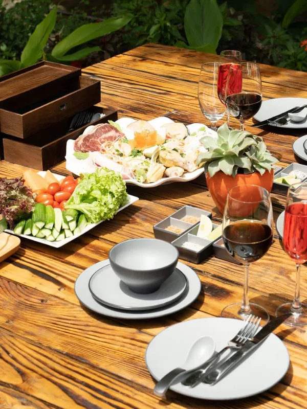 Artisanal charcuterie and fresh forest greens platter served on a rustic timber table