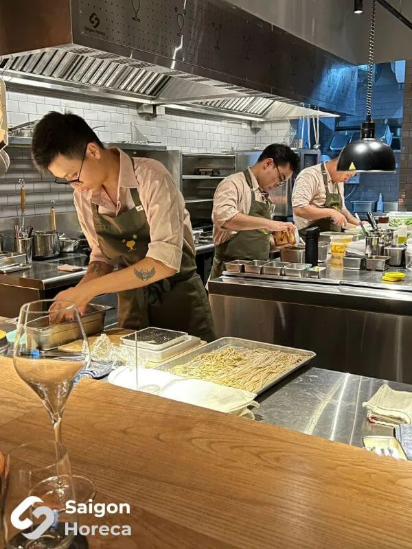 Chefs operating with precision along the hot line at Little Bear Thao Dien
