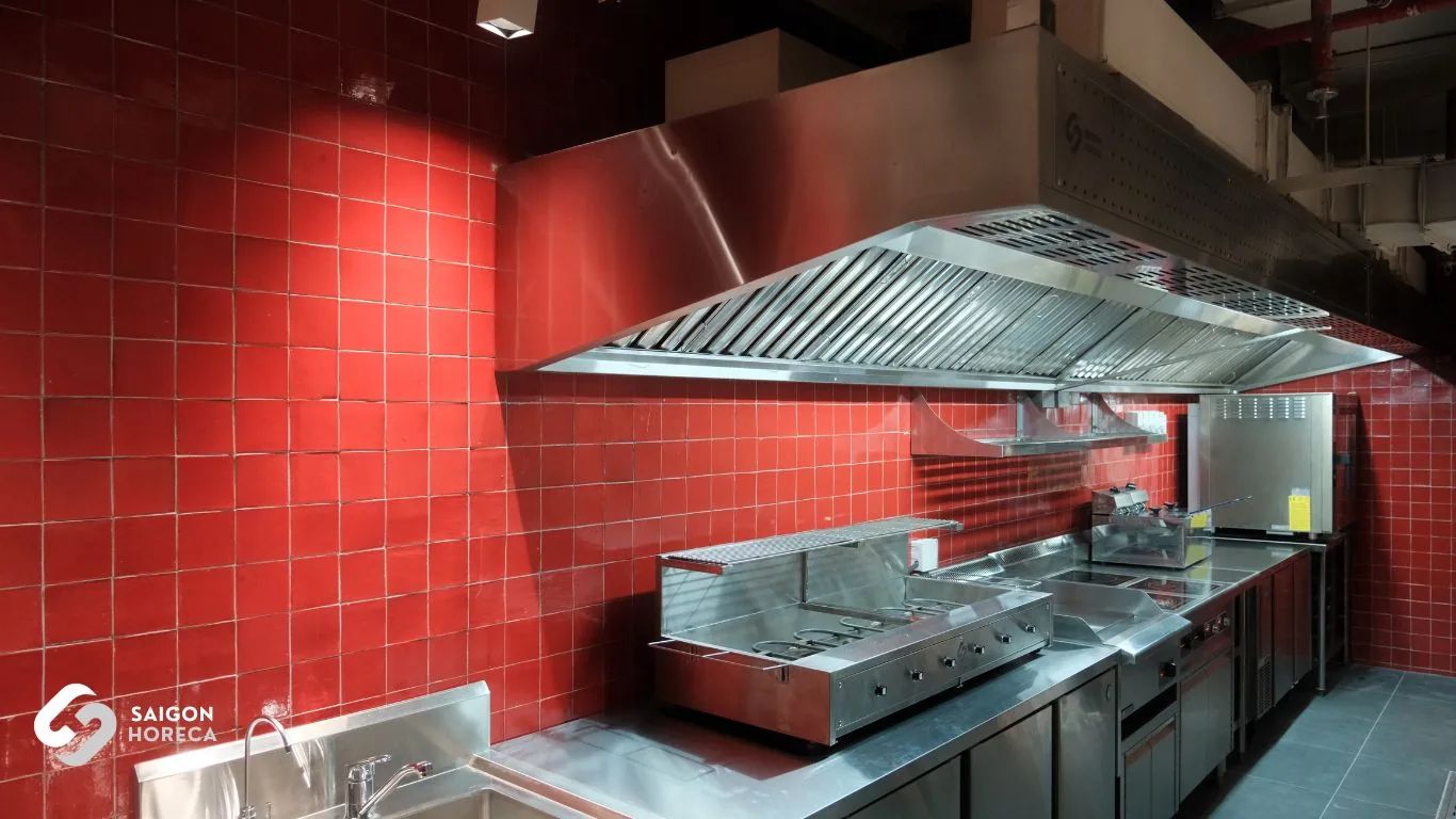 Mam Mam commercial kitchen featuring a large stainless steel canopy exhaust hood, high-output gas range, and reach-in chillers against red ceramic brick tile walls