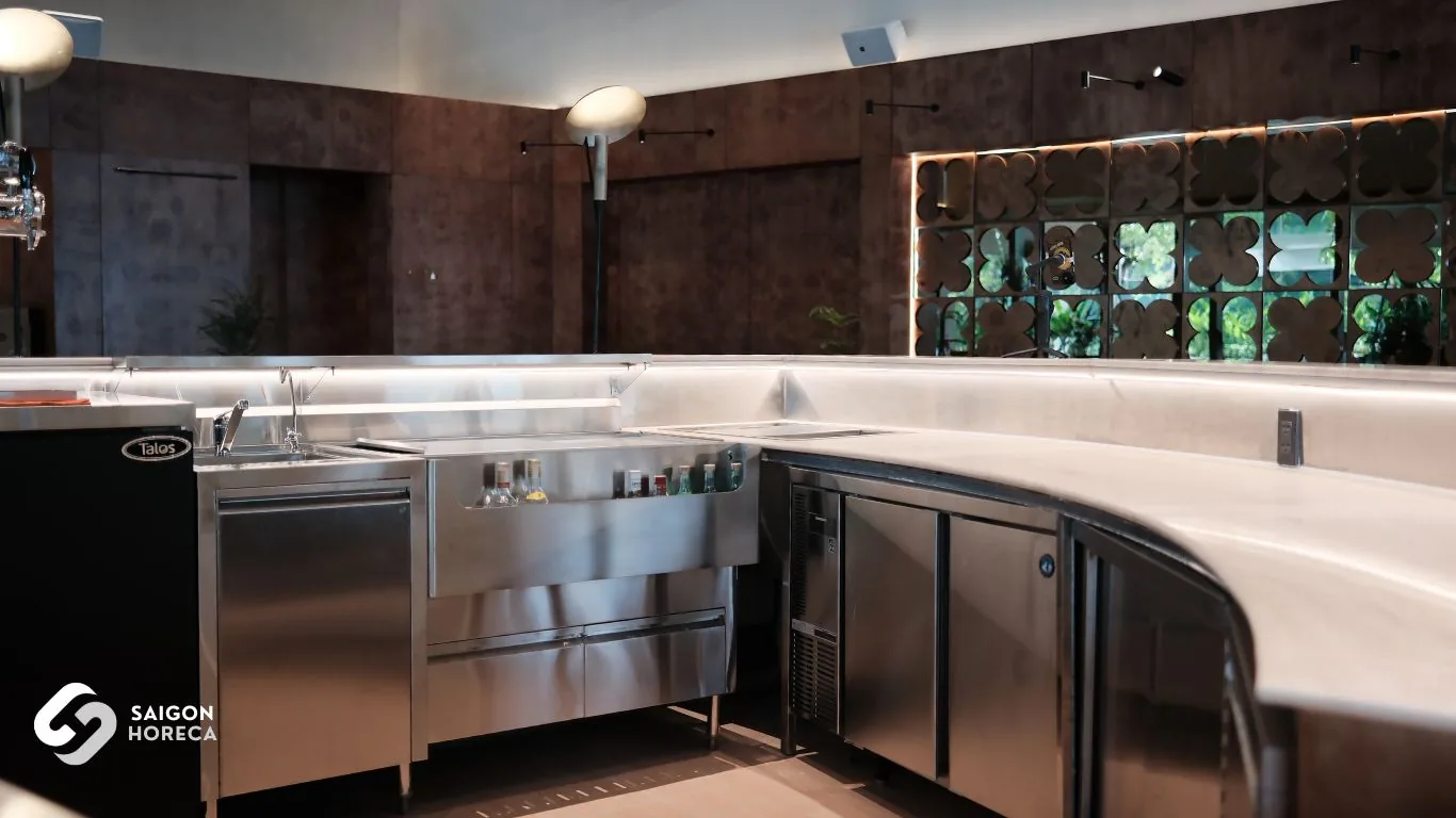 Curved stainless steel bar counter integrating rinse sinks, under-counter chillers, and a draft beer tower fabricated by Saigon Horeca at Mam Mam