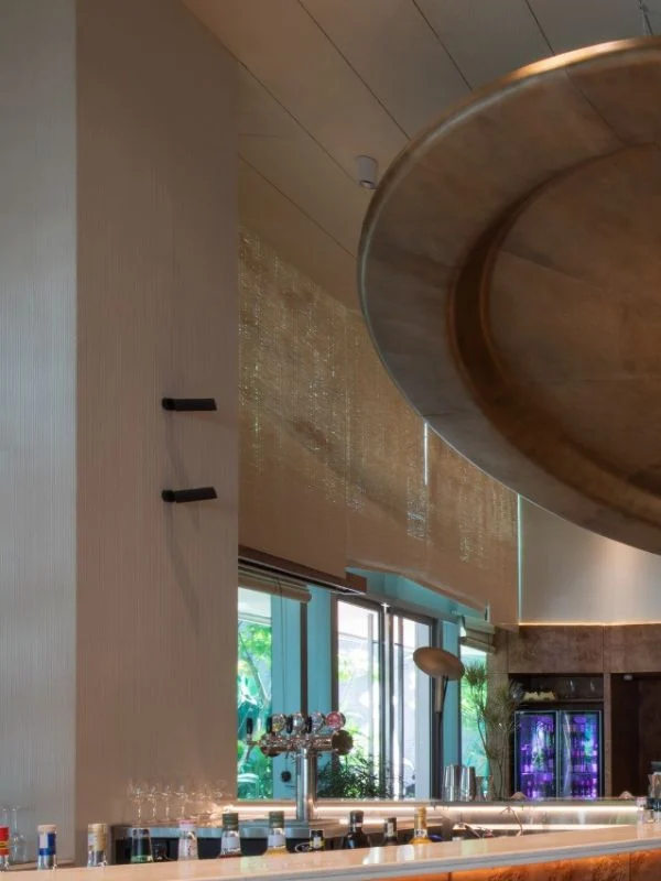 Detail of antique copper ceiling installation and curved stainless steel bar at Mam Mam
