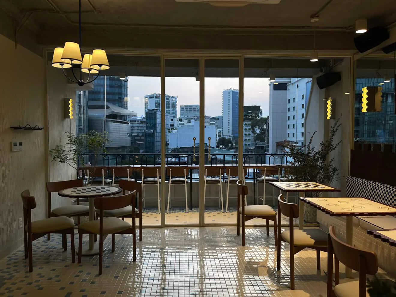 Indoor dining area featuring wooden furniture and floor-to-ceiling glass windows overlooking District 1 at Moa Moa