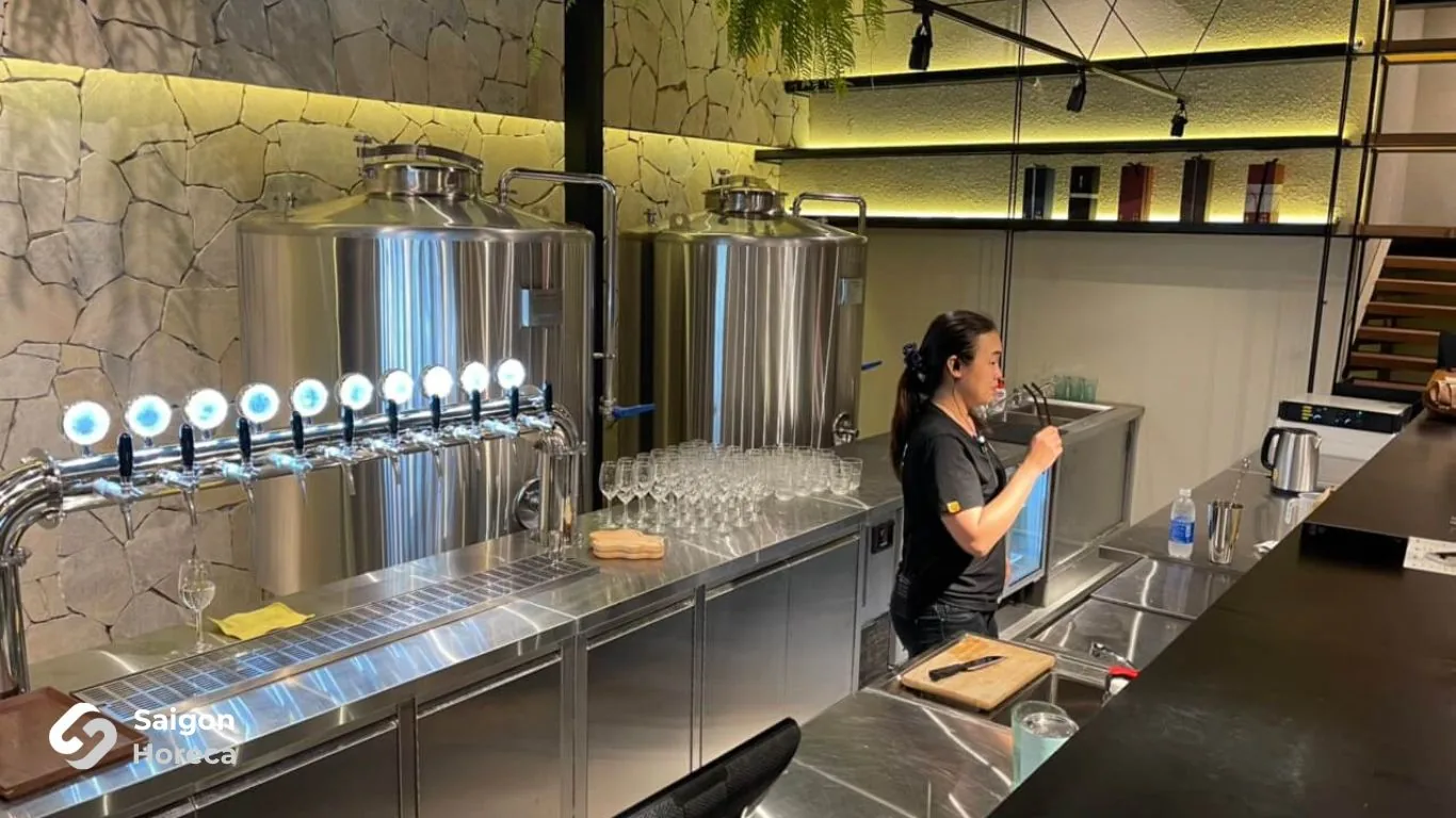 Sake dispensing bar counter with stainless steel draft station at Mùa Craft Sake