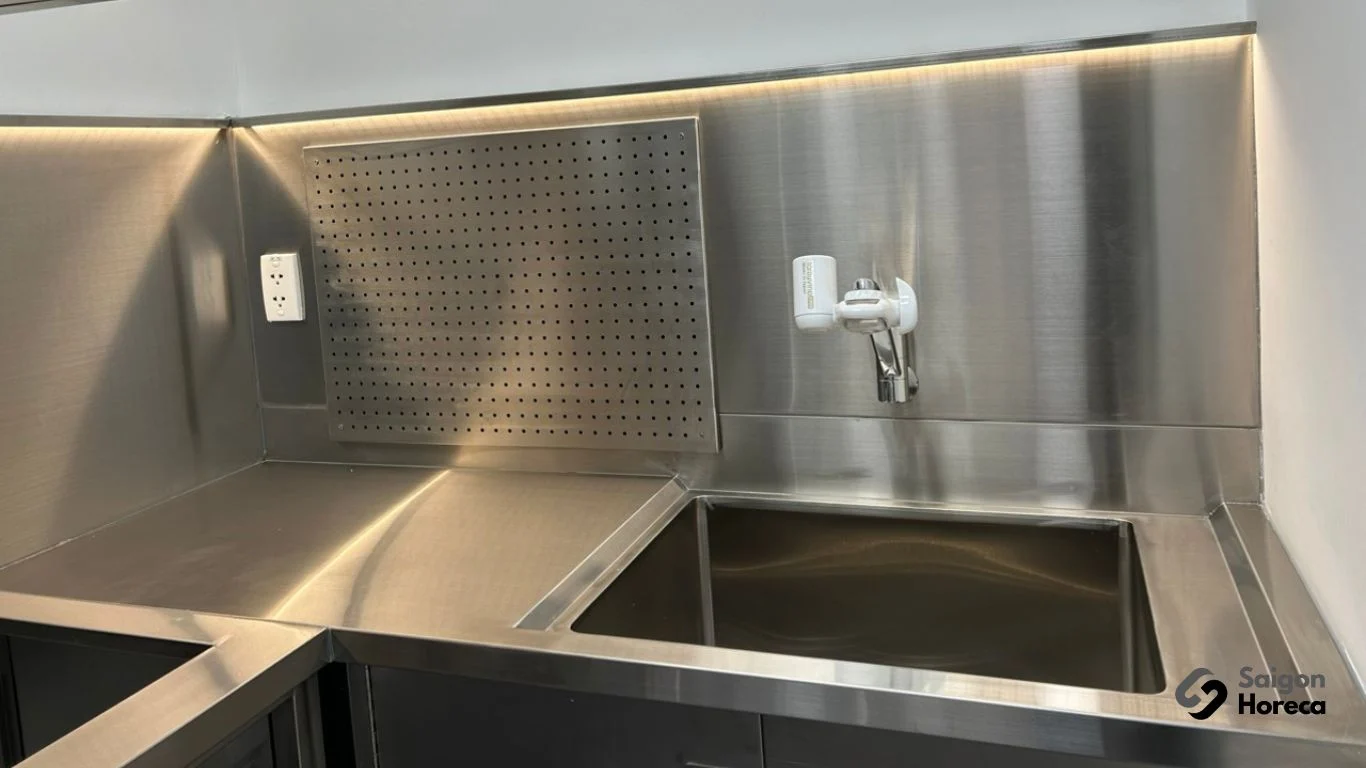 Under-mount stainless steel sink station at Nichiyo industrial kitchen corner featuring perforated stainless backsplash and water purification faucet