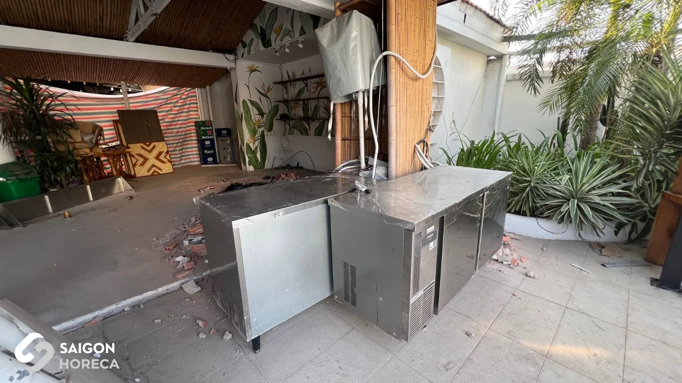 Positioning stainless steel kitchen counters during renovation amidst masonry demolition debris at Sol Kitchen & Bar District 7.