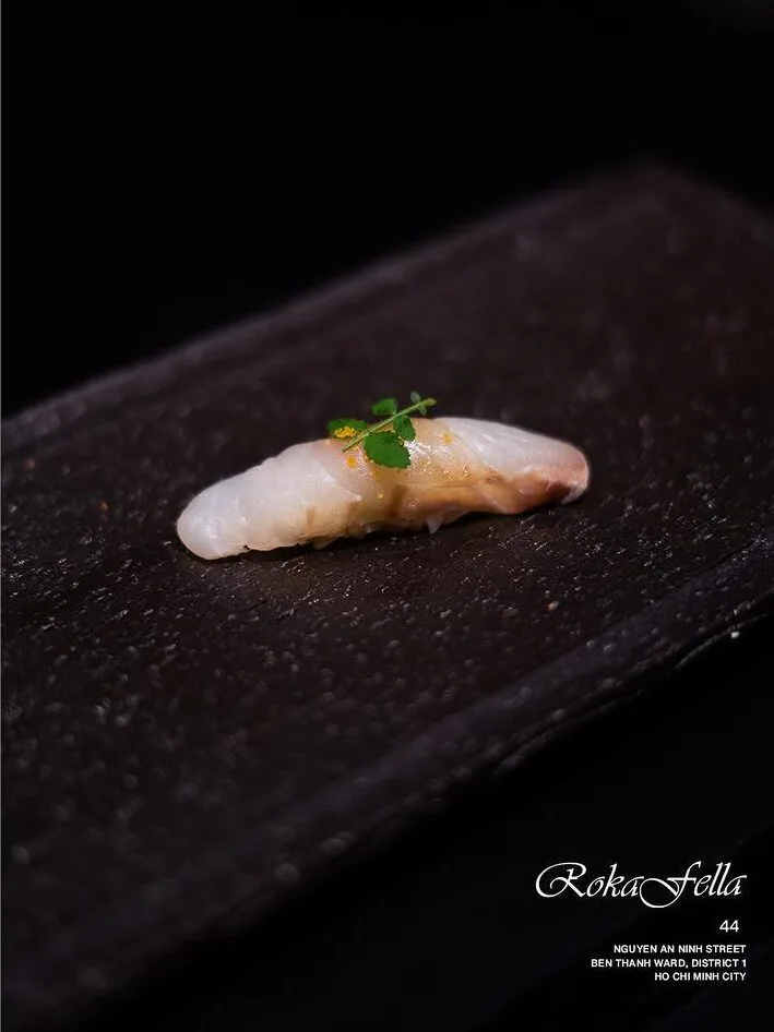 Madai red sea bream nigiri accented with fresh botanical herb leaves at Roka Fella.