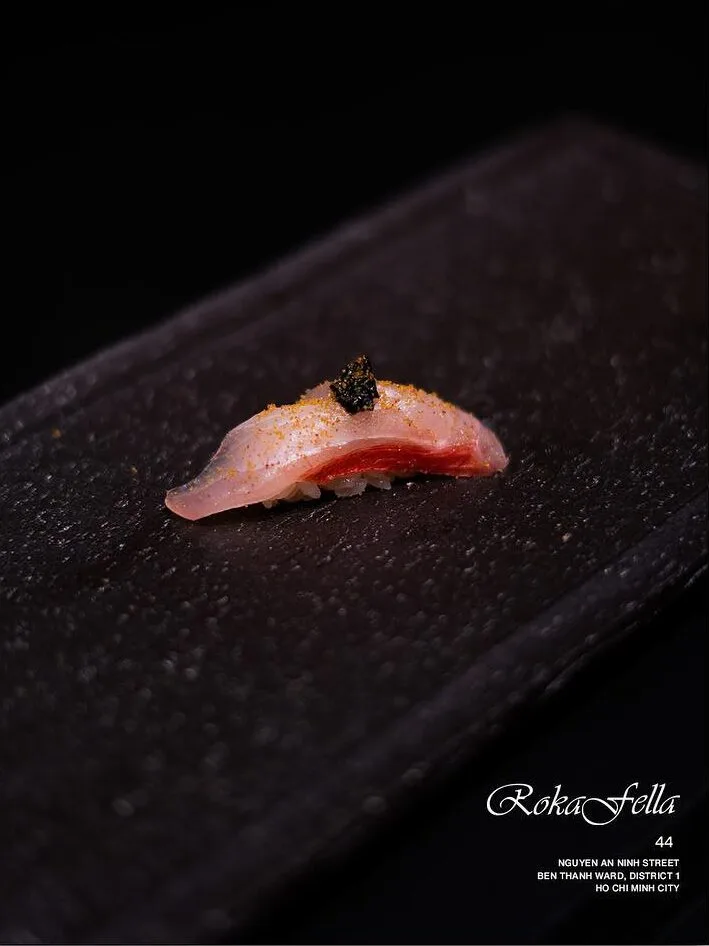 Lightly seared Kinmedai golden eye snapper nigiri dressed with black garlic reduction at Roka Fella.