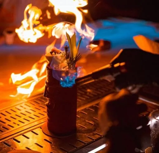 Flaming cocktail presentation at the Skyloft by Glow bar counter.