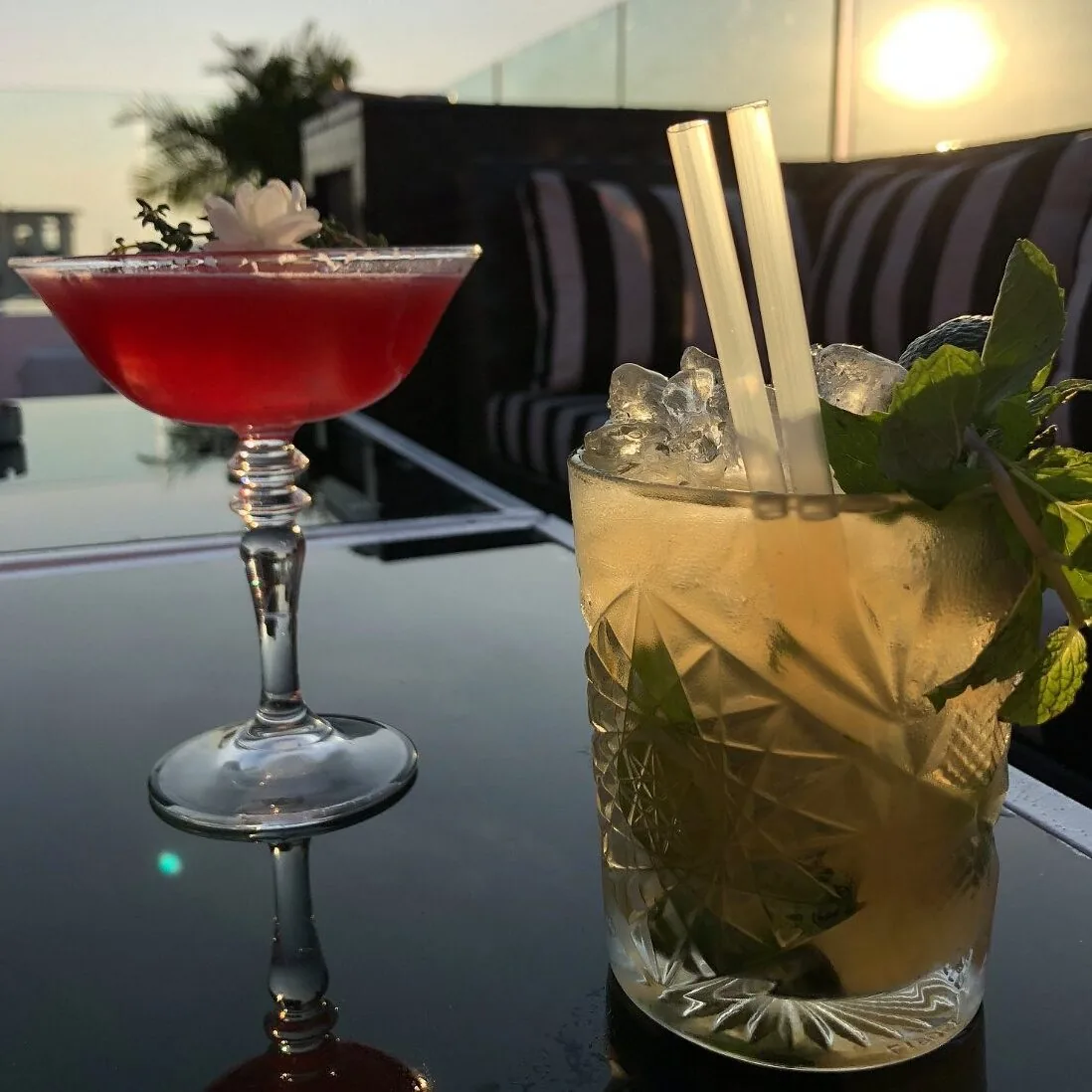 Signature Skyloft by Glow cocktails served on glass table at twilight sunset.
