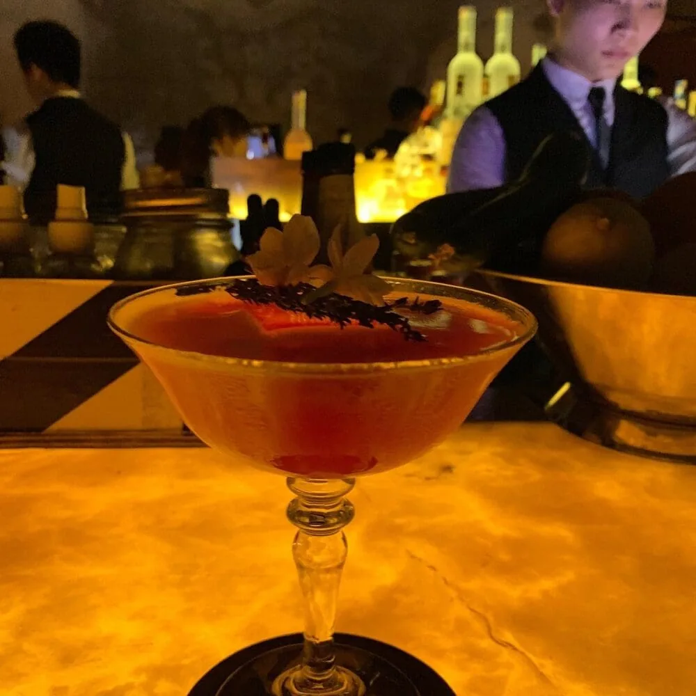 Crimson craft cocktail staged on the Skyloft by Glow bar top.