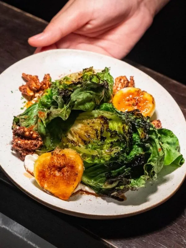 Pan-charred baby gem salad served with caramelized orange segments and creamy dressing at Sol Kitchen & Bar