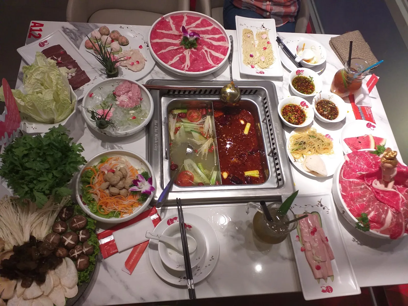 Iconic Wagyu Barbie doll beef platter alongside dual-broth Sichuan hotpot setup at Spice World Hot Pot