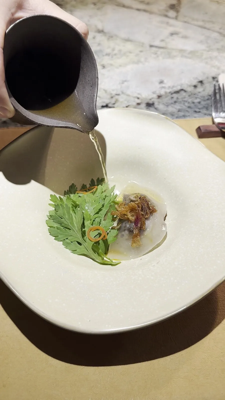Delicate botanical consommé amuse-bouche
