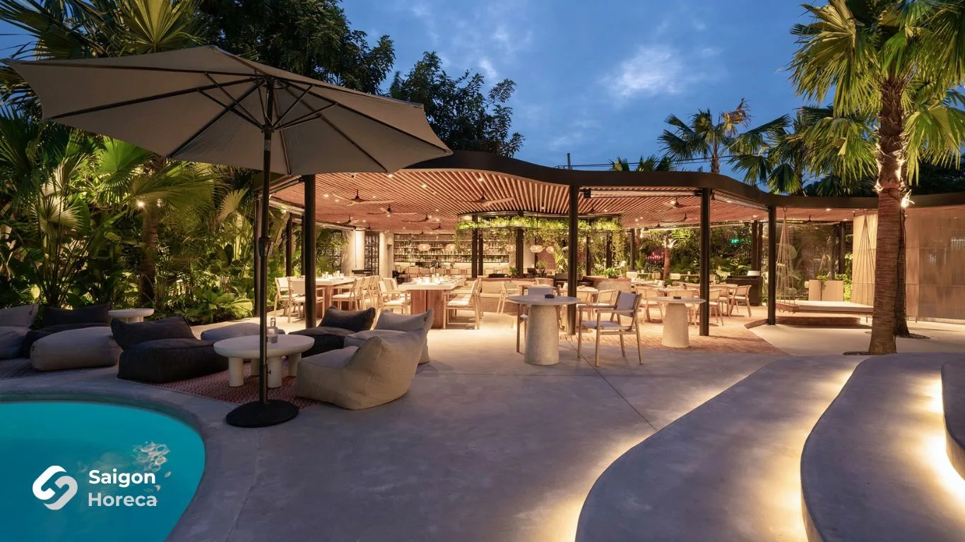 The Brix outdoor lounge featuring umbrellas and poolside sofas at dusk