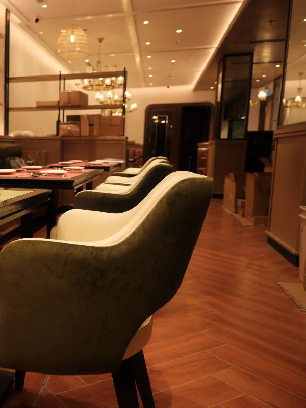 Premium moss-green velvet upholstered chairs and timber dining table at The Royal