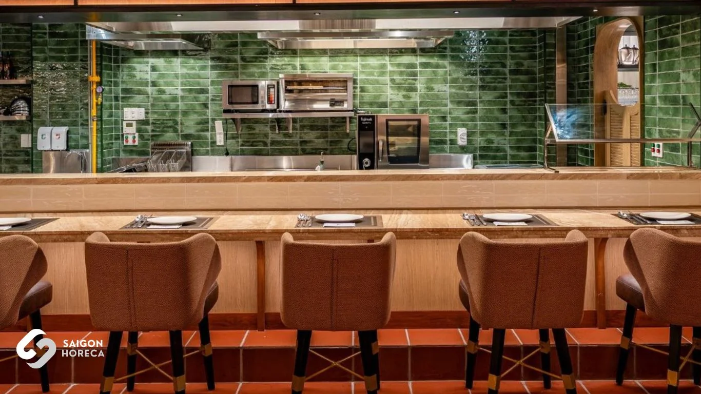 Signature moss green subway-tiled open kitchen featuring Fujimak cookline and cozy brown tweed bar seating at The Royal All Day Dining