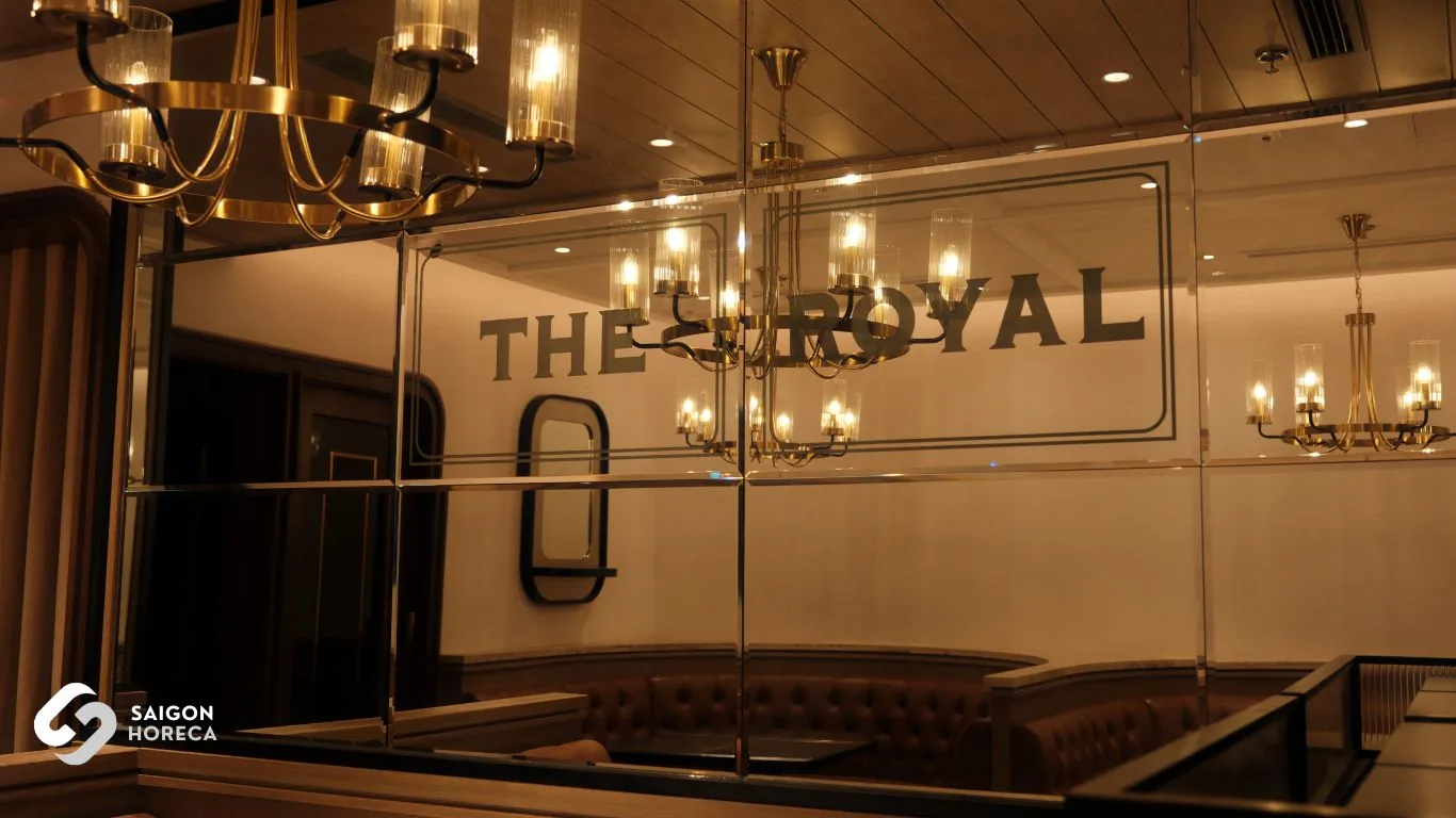 Luxurious diamond-beveled mirror paneling reflecting the bar lounge and embossed The Royal All Day Dining insignia