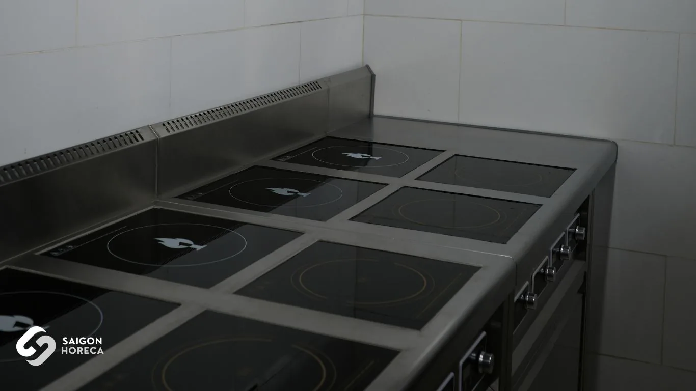 Multi-zone commercial induction cooktop with black vitroceramic glass and stainless steel chassis — The primary culinary workhorse installed by Saigon Horeca at Nam An