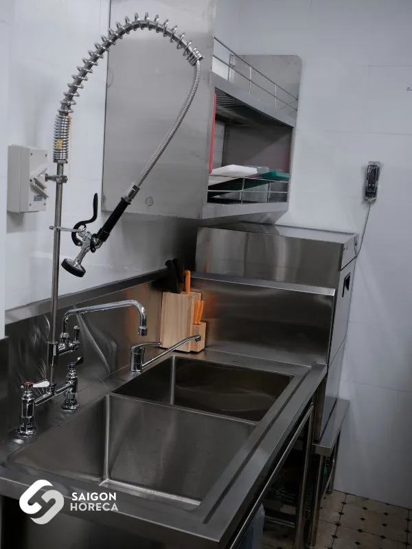 Double-bowl stainless steel prep sink with spring-action pre-rinse spray unit in the Nam An pre-wash zone