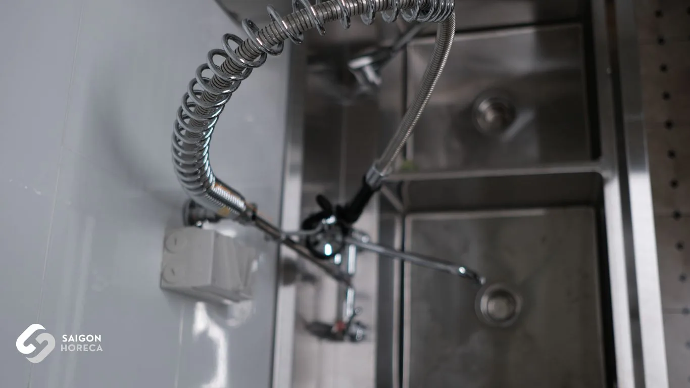 Heavy-duty commercial pre-rinse spray valve with spring-action hose at Nam An dishwashing station