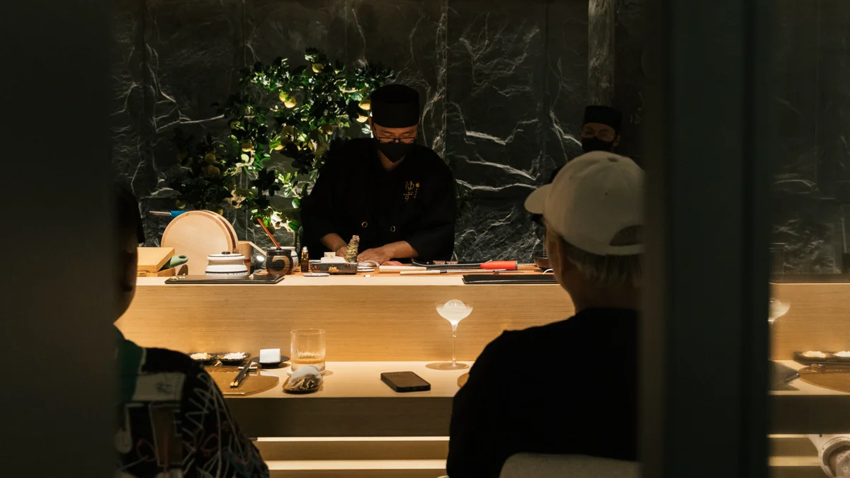 Guest viewpoint enjoying the immersive Omakase artistry along the serene Zen bar counter