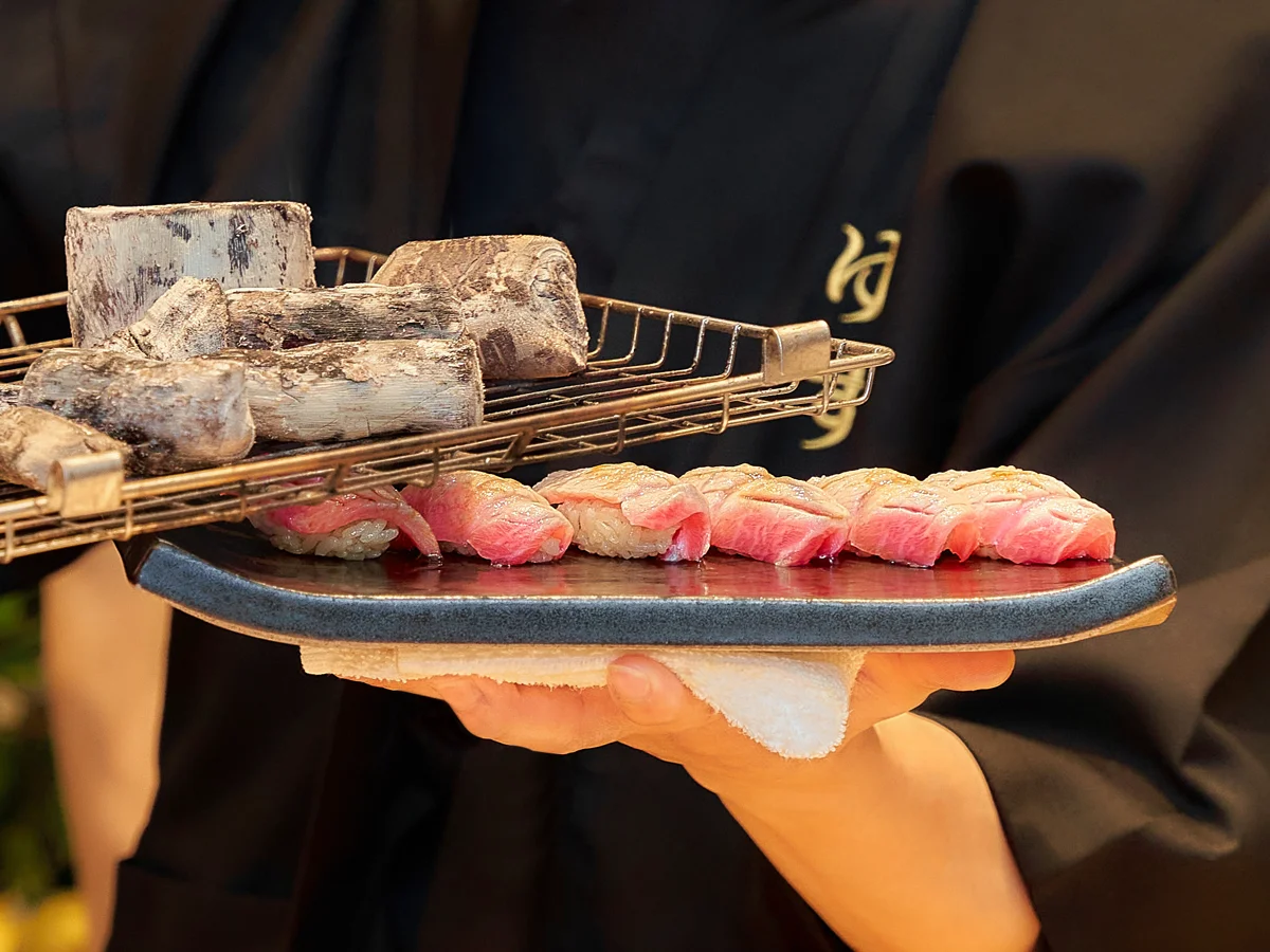 Traditional Binchotan charcoal searing technique releasing the rich marbling of Wagyu beef and fatty Otoro bluefin tuna