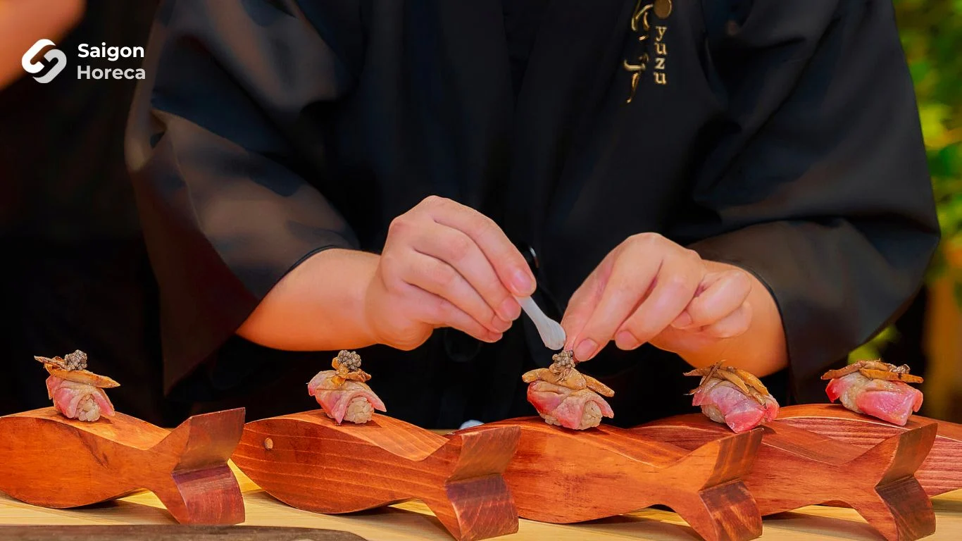 Artisanal Nigiri plating on hand-carved wooden fish plinth adorned with edible gold leaf and royal caviar